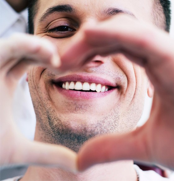 smiling man making heart with his hands